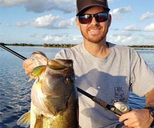 Man smiling holding Largemouth Bass